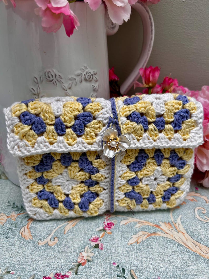 White, yellow and periwinkle granny square crochet pouch with flower button