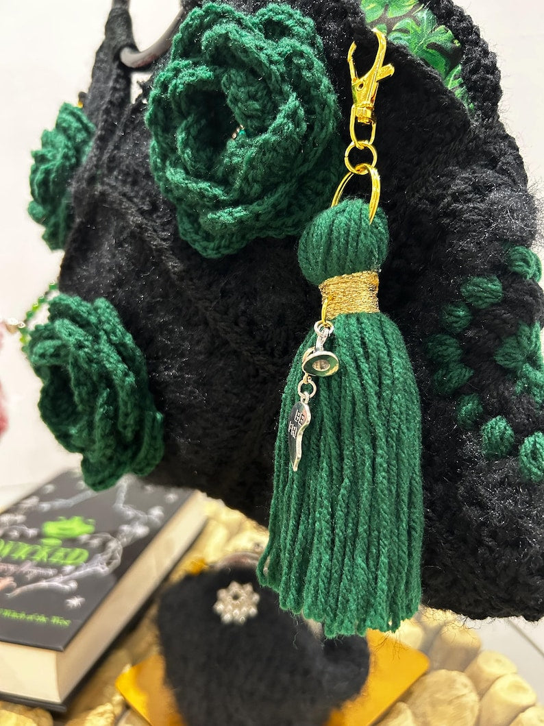 Black crochet bag with green floral accents and tassel keychain