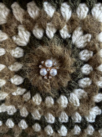 Close-up of granny square with pearl brooch