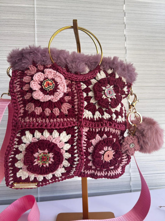 Side view of the floral crochet bag with gold handles