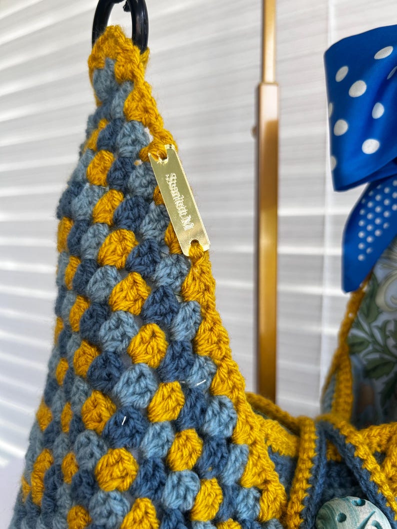 Crochet bag with decorative button and bow