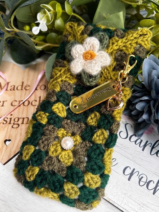 Green and brown crochet glasses case with white flower