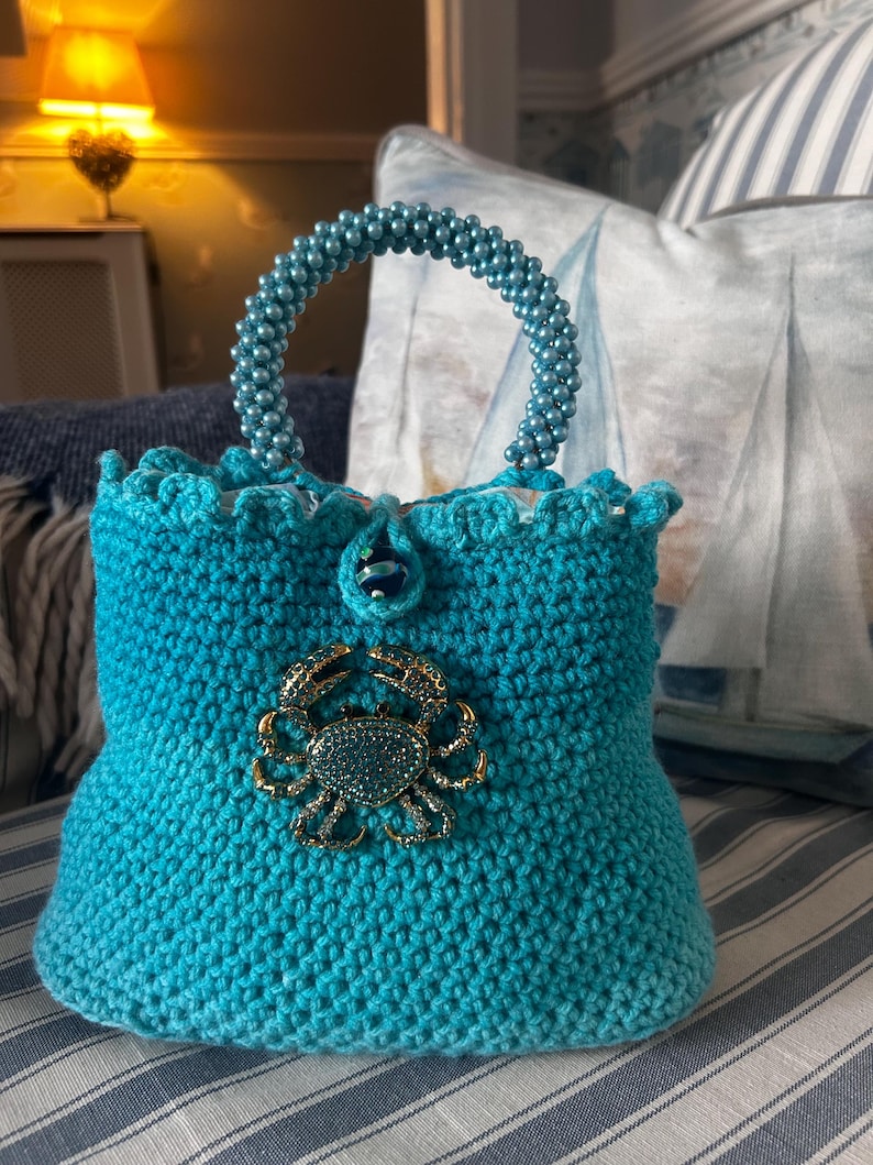 Turquoise crochet bag with gold crab clasp and scalloped edge