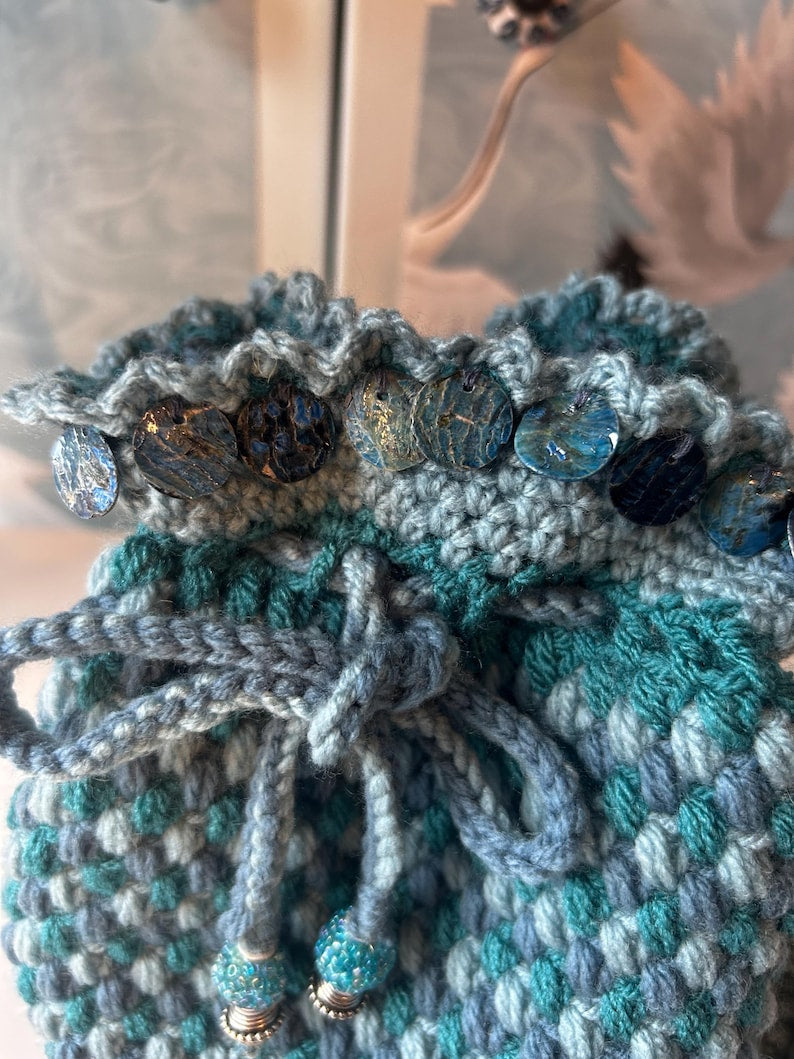 Crochet pouch with iridescent buttons and beaded tassels