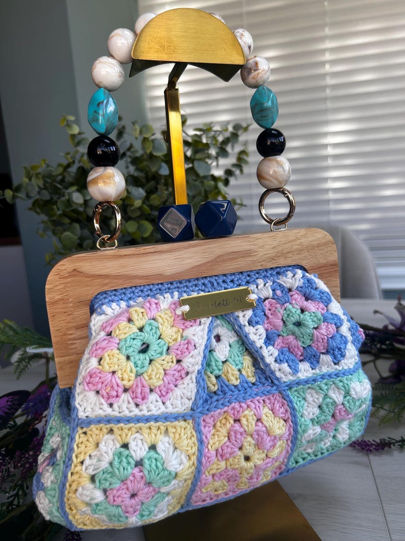 Pastel crochet clutch with beaded handle and gold tag