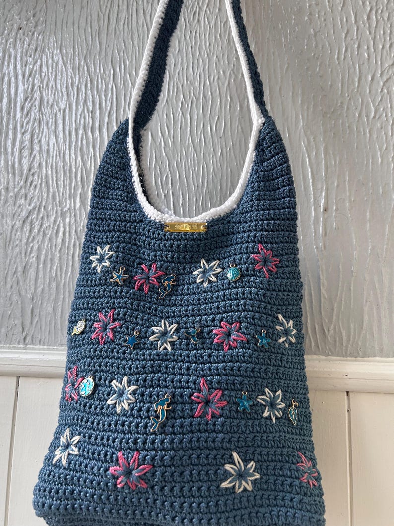 Blue crochet bag with embroidered star flowers and sea charms