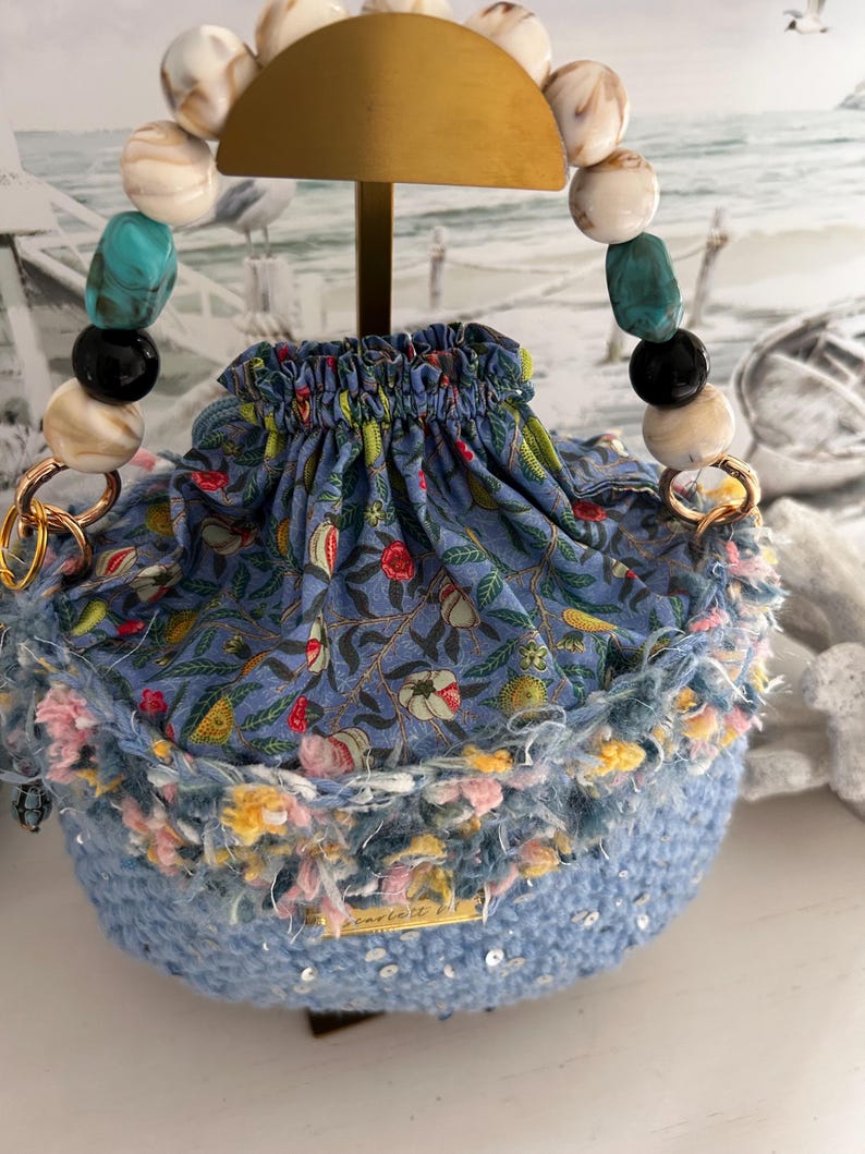 Round light blue crochet bag with drawstring and multicolour beaded handle