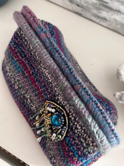 Ocean-toned crochet piece with blue gemstone brooch detail