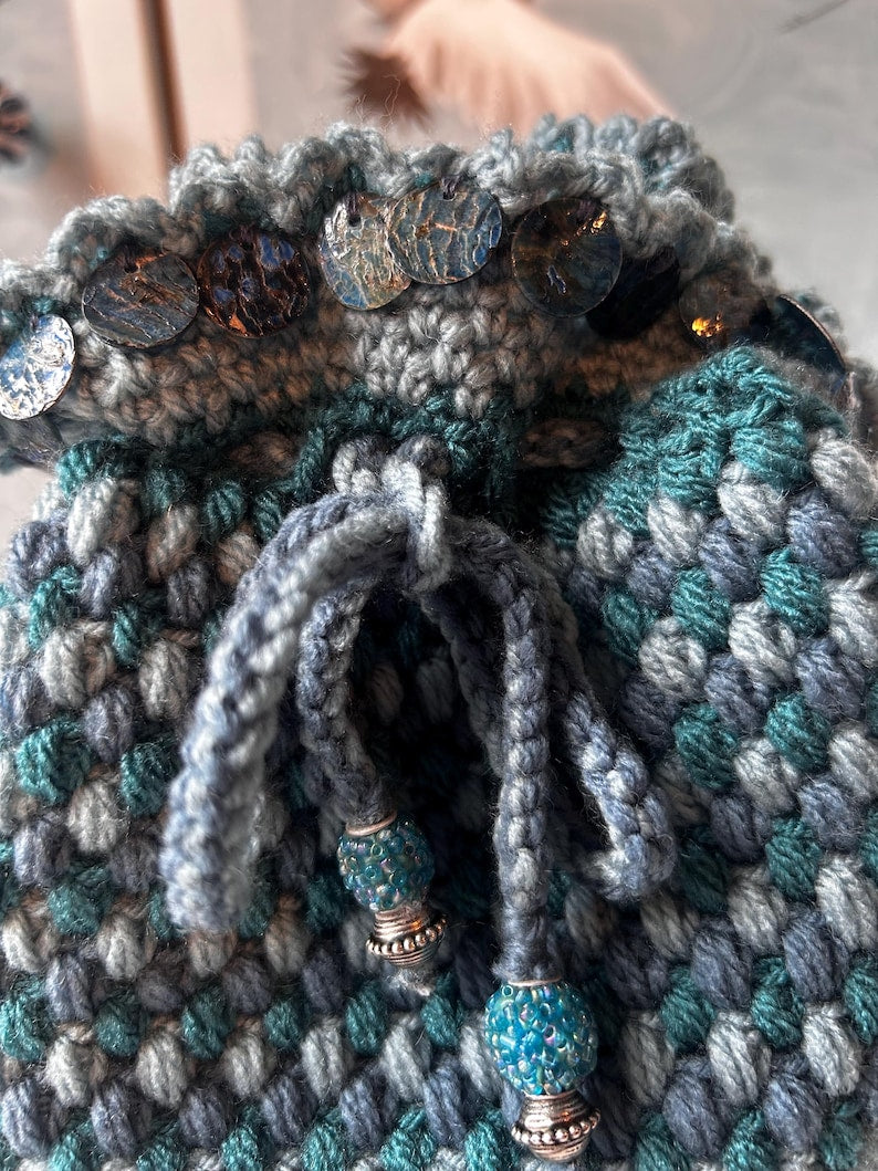 Teal drawstring pouch with metallic discs and beaded cords