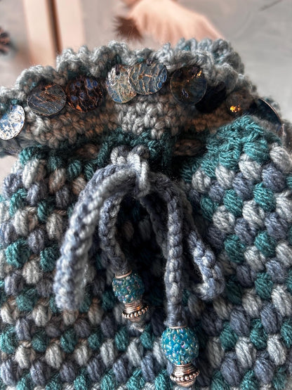 Teal drawstring pouch with metallic discs and beaded cords