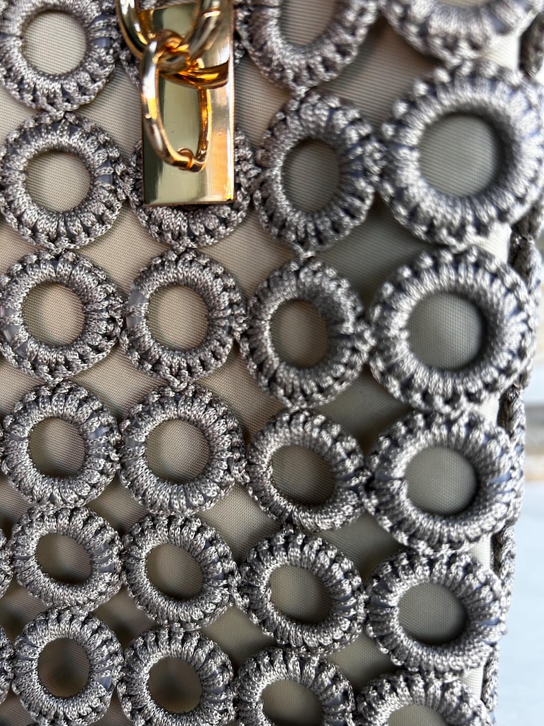 Beige tote with gold clasp and patterned gray crochet circles