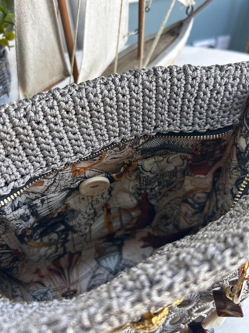 Gray crochet tote with map-print interior lining and button clasp