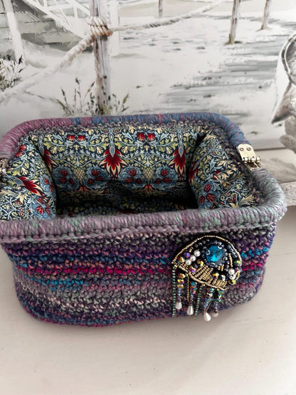Crochet clutch with floral lining and blue gem brooch