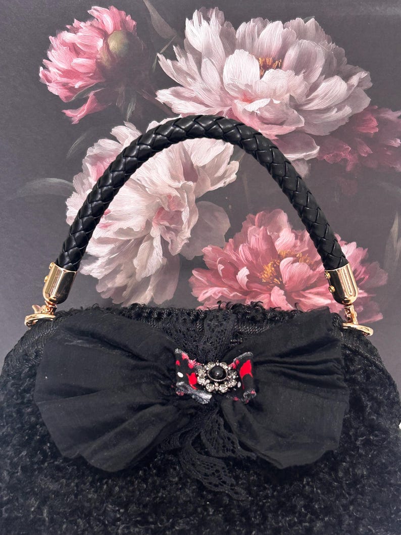 Black textured handbag with bow and crystal brooch