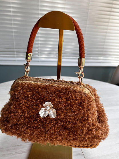 Brown fluffy handbag on gold stand with silver flower