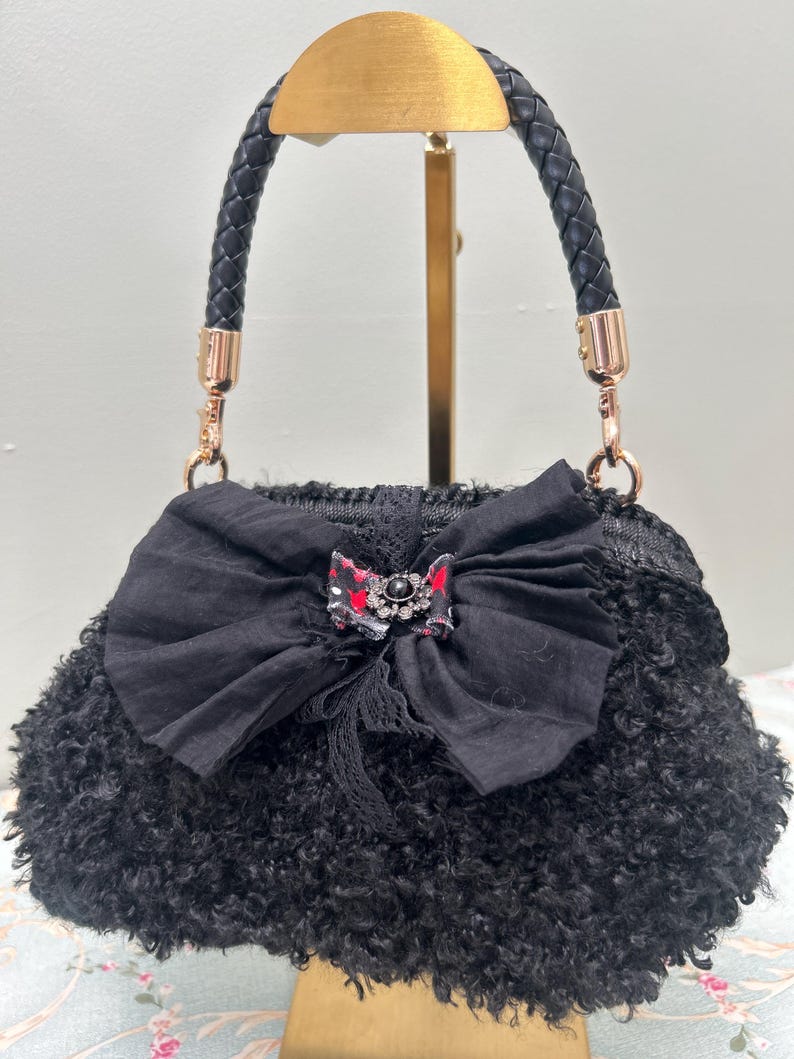 Black fuzzy handbag with large bow and jewel centre