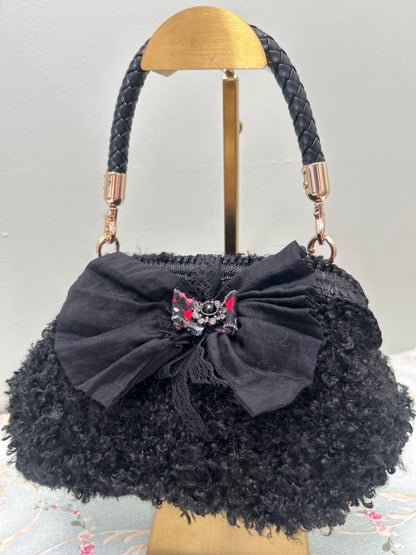 Black fuzzy handbag with large bow and jewel centre