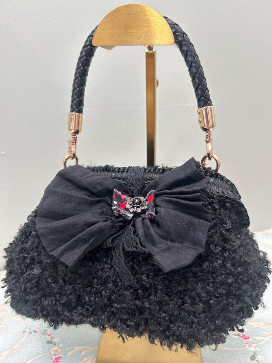 Black fuzzy handbag with large bow and jewel centre