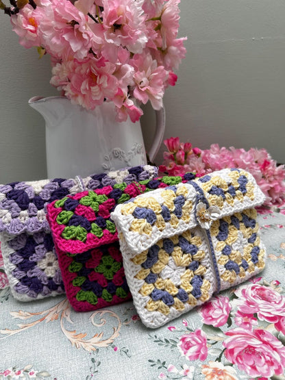 Three floral granny square crochet pouches in assorted colours